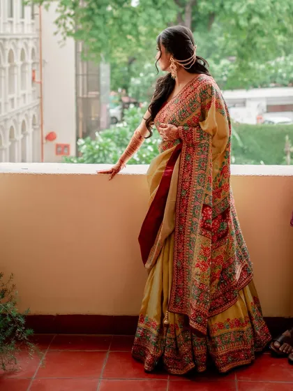 A beautiful solo portrait of the bride, showcasing her traditional saree and elegant hairstyle for the Mehendi.