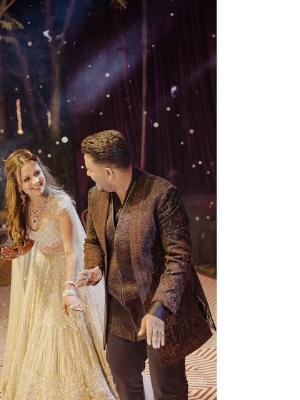 A candid moment of laughter during their Sangeet night. Even in motion, their coordinated shimmer and elegant outfits look picture-perfect.