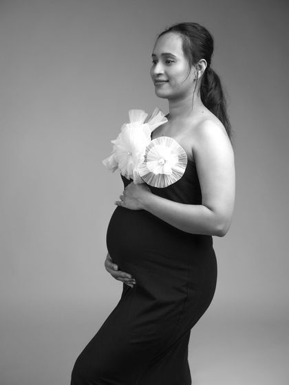 A classic black and white profile shot. This timeless style beautifully highlights the silhouette of the baby bump.