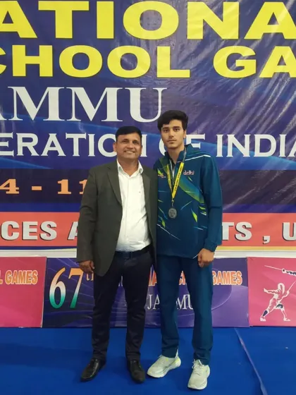 A coach and his student fencer share a moment of pride after a medal win at the 67th National School Games. This is the result of focused training and dedication.