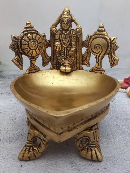A heart-shaped brass diya featuring Lord Balaji with Shanku and Chakra. This is a very special piece for devotees of Venkateshwara Swamy.