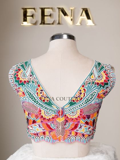 I designed this unique 'Butterfly Garden' blouse for the bride who loves color and artistry. The entire piece is covered in a vibrant mosaic of multi-colored beads and sequins, forming a stunning butterfly motif across the back.