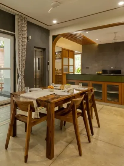 The dining area at Villa 17, featuring a solid wood dining table and chairs. The space opens onto a patio, blurring the line between indoors and out.