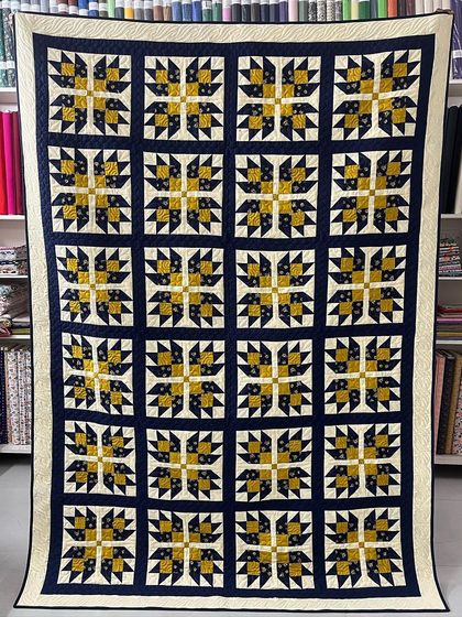 A Bear Paw quilt in a classic blue and yellow color scheme.