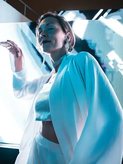 A performer dancing against a backdrop of bright lights and visuals. We incorporate live performers to add another layer of entertainment to our themed nights.