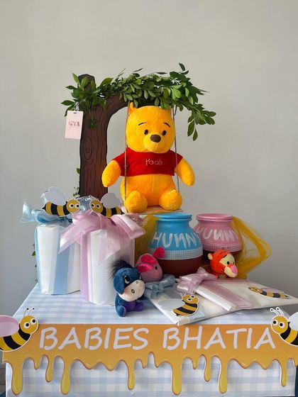 A full view of the Winnie the Pooh hamper, personalized for 'Babies Bhatia' with a honey-drip banner and adorable character toys.