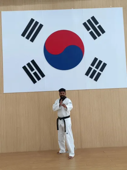 Standing before the Taegukgi, the flag of South Korea, the birthplace of Taekwondo. A symbol of the deep respect we have for the art's origins.