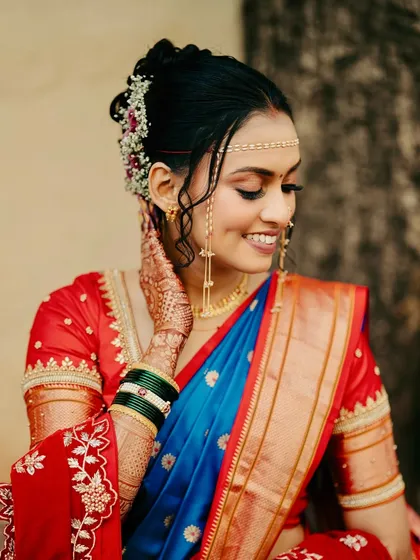A close-up on the details. The delicate mundavalya, face-framing curls, and flawless skin come together to create a picture-perfect bridal look.