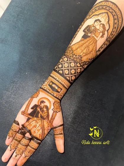 I love creating both modern and traditional looks. This design features a romantic couple on a swing on the palm, complemented by a contemporary portrait on the forearm, showing how we can blend different styles for a full bridal look.