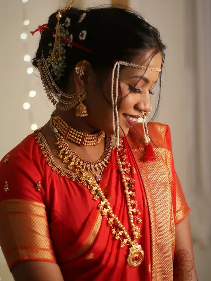 A candid, downward glance from the bride. This shot highlights her long lashes, blended eyeshadow, and the intricate Khopa hairstyle.
