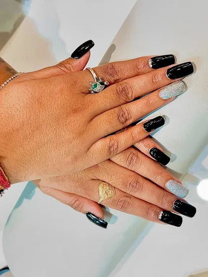 This client is showing off her black and silver glitter nails, perfectly complementing her bracelets.