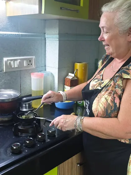My kitchen is a hands-on space. You won't just be watching, you'll be chopping, stirring, and frying yourself. Here's a guest from my recent Mumbai cooking class getting the hang of tempering spices for a classic Maharashtrian dish.