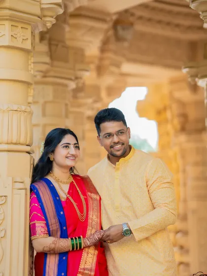 A bright and happy portrait of the couple framed by ornate pillars. The natural light and their joyful expressions make this a standout shot.