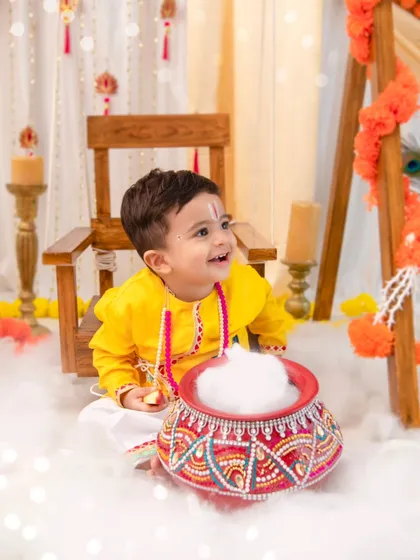 A playful 'Little Kanha' with his pot of butter. Themed shoots are all about telling a story, and this one is full of divine mischief and charm.