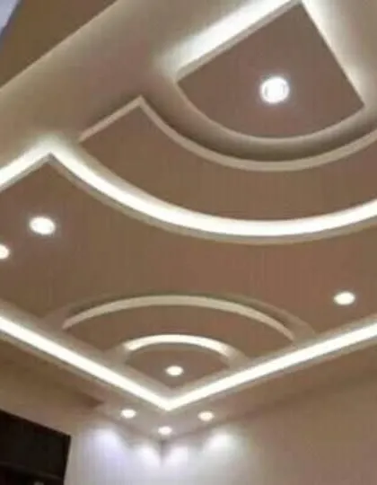 This design uses curved cutouts within a square frame, softening the geometric look. The warm cove lighting highlights the smooth curves of the POP work.