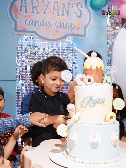 The birthday boy is all smiles as he gets ready to cut his incredible "Candy Shop" themed cake. We love creating these moments of pure joy and excitement.