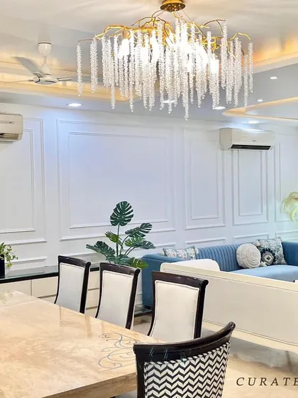 This living and dining room refurbishment shows how a space can be transformed with a calm and elegant vibe. By introducing classic wall paneling, a statement chandelier, and a soothing color palette of blues and whites, I created a sophisticated and inviting atmosphere.
