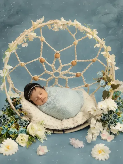 A dreamy, peaceful portrait of a newborn baby girl. I use props like this beautiful dreamcatcher and soft floral arrangements to create a magical and serene setting for your baby's first photoshoot.