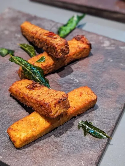 Fried tapioca, or 'Kappa Varruthathu', is a beloved Kerala snack. These tapioca fingers are crispy, savory, and garnished with fried curry leaves. It's simple, delicious, and very addictive.