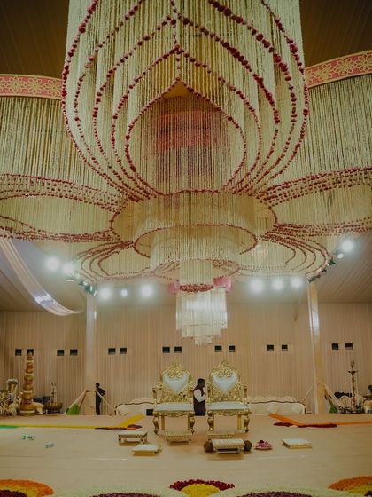 An incredible ceiling installation made entirely of flowers, designed in a lotus pattern. This is the kind of large-scale floral art we create for a truly royal wedding hall.