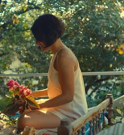 A serene moment from the "Made to Move" music video, with soft, natural makeup that complements the morning light.