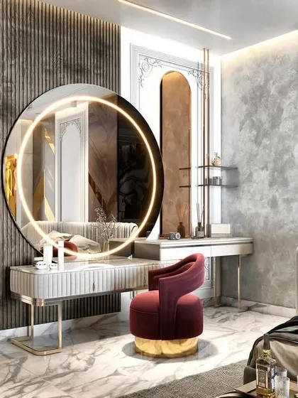 A chic and modern vanity setup that feels both glamorous and functional. The large, round backlit mirror serves as a statement piece, while the fluted details on the desk and the plush velvet chair add layers of texture and color.