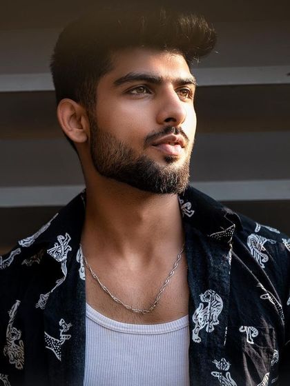 This portrait showcases a casual, layered look. The natural light and simple background make it a versatile shot for a model's book, suitable for both commercial and lifestyle contexts.