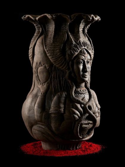 A side view of the 'Cosmic Temple' sculpture, showing the sun and moon motifs. This piece represents holding the cosmos within, a concept central to my spiritual practice and artistic expression.