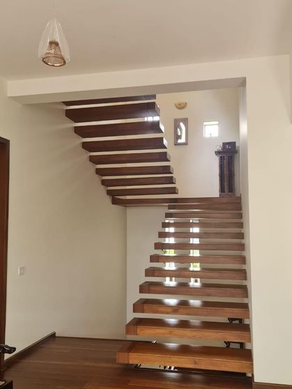 A real-life photo of a floating wooden staircase from one of our completed projects, demonstrating our expertise in creating architectural features that are both functional and beautiful.
