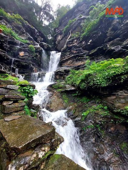 The rocky cascade of Bheemeshwara Falls, surrounded by lush green moss and foliage.