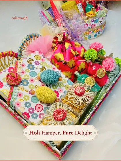 This Holi hamper is pure delight. The floral-themed tray is artfully arranged with notebooks, crochet items, and jars of treats, offering a unique and creative gift.