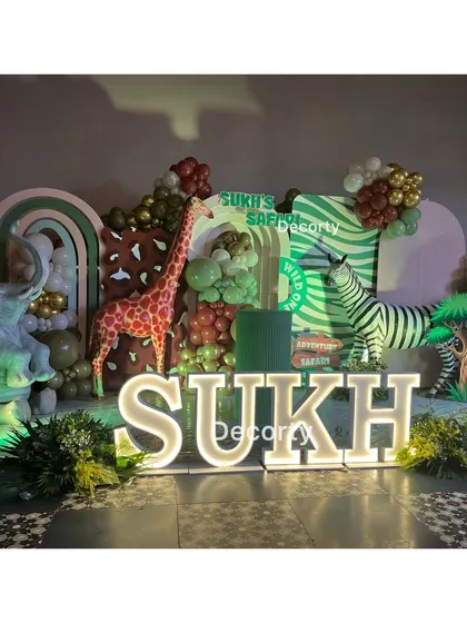 A personalized stage for "Sukh's Safari" with large illuminated letters and various animal props.
