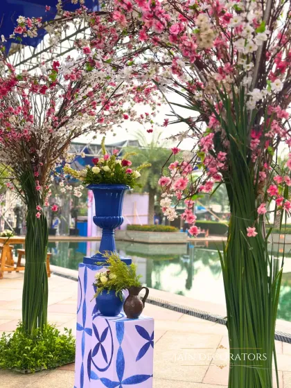 A pop of color by the poolside. I used cherry blossom trees and vibrant blue vases to create a striking visual contrast, adding a touch of artistry to the outdoor space.