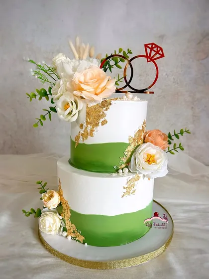A lovely two-tier engagement cake with a pop of green. The fault line design is accented with gold leaf and beautiful white and peach florals.