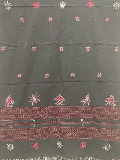 This black woollen shawl features a striking red border and motifs from Kasuti and Negi embroidery traditions. It's a bold and beautiful piece to keep you warm.