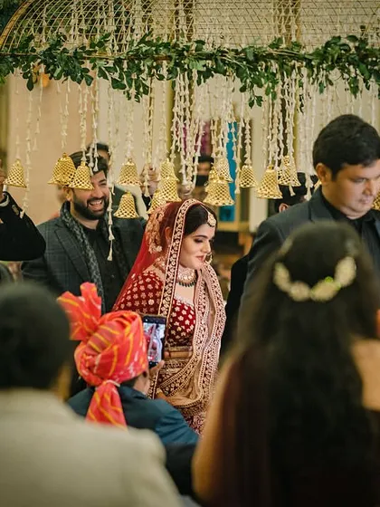 The bride's entry under a canopy of bells, a unique and beautiful twist on the traditional phoolon ki chaadar.