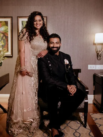 This couple looks so elegant. The bride's curly hair is styled beautifully, and her makeup is glamorous yet natural, perfect for her reception.