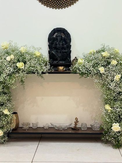 For a touch of elegance at a home entrance, I created this beautiful arch around a Ganesha idol using baby's breath and white roses. It's a serene and graceful decoration for any auspicious occasion.