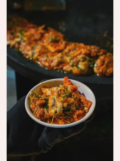 The final product of our 'Grillax Gourmet' station. A bowl of freshly grilled vegetables smothered in a thick, cheesy sauce, ready to be enjoyed.