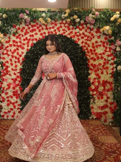 Twirl-worthy and fabulous. A happy client in a heavily embellished rose pink rental lehenga, perfect for an engagement or wedding reception. The silver work shines beautifully under the lights.
