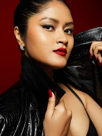 A powerful and classic look with a sharp winged liner, a bold red lip, and a sleek leather jacket.