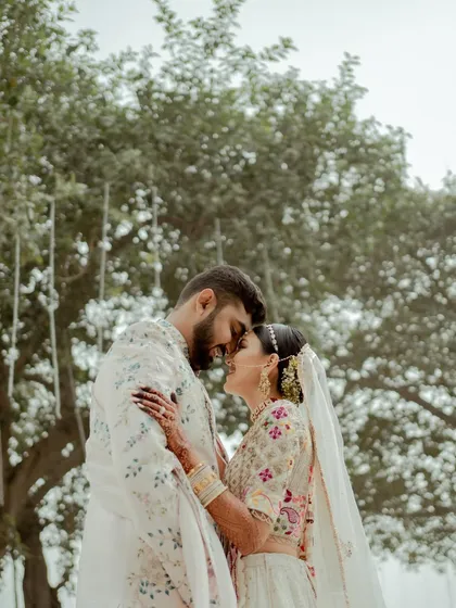 A beautiful, intimate moment between Disha and Herin on their wedding day. This shot captures the quiet connection and happiness of the couple in their stunning traditional attire.