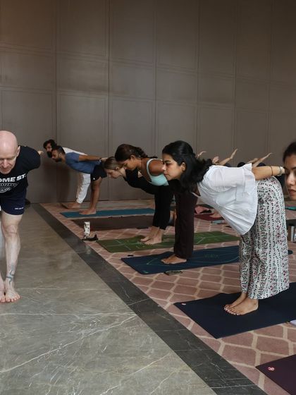 Practicing Ardha Uttanasana alongside Eddie Stern and fellow students. Learning in a group setting allows us to refine our own practice by observing and moving together.