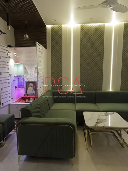 This view of the living room shows the seamless integration of a modern home mandir. The design ensures the sacred space is a harmonious part of the overall living area while maintaining its distinct, peaceful identity.