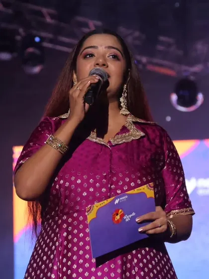 Another expressive shot from the grand finale, holding the mic and connecting with the audience.