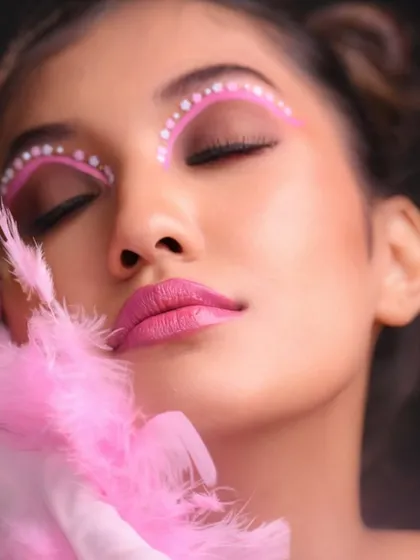 A close-up with a feather prop, adding texture and softness to the image.
