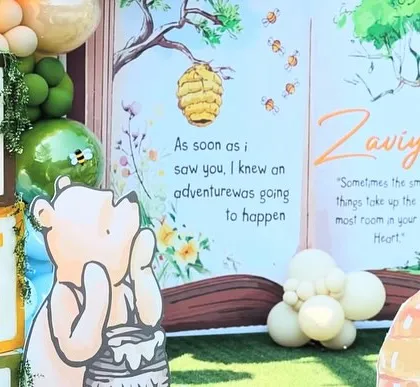 The setup includes 'ONE' blocks and a thoughtful Pooh Bear, creating a perfect scene for first birthday photos.
