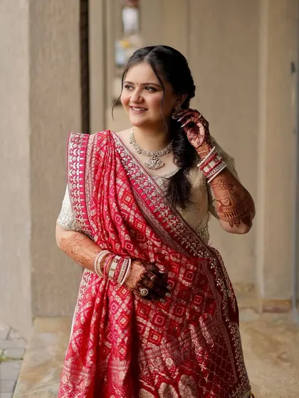 Another angle of this serene look. The soft braid and the way the red bandhani dupatta contrasts with the ivory lehenga is simply beautiful.