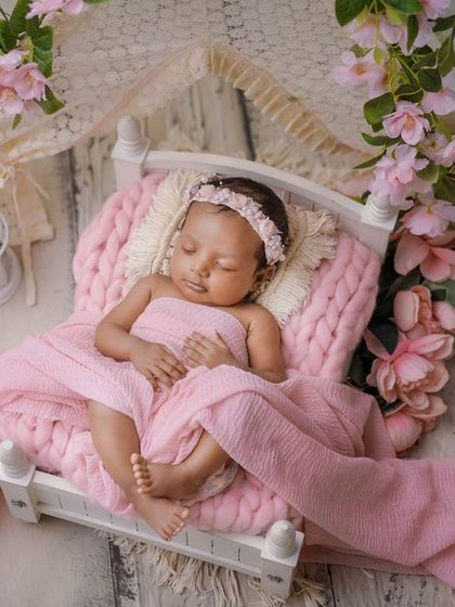 A bed of pink flowers. This dreamy setup uses a miniature bed, soft pink fabrics, and a canopy of blossoms to create a fairytale scene.