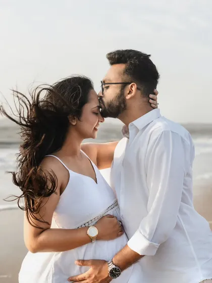 A gentle kiss on the forehead is always a perfect shot. We captured this tender moment on the beach, with the wind catching her hair. It feels so natural and full of love.